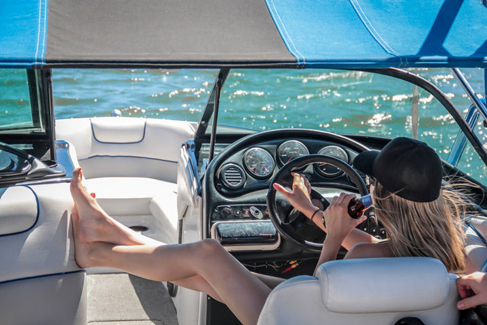 A boater relaxes and drinks out on the open water.