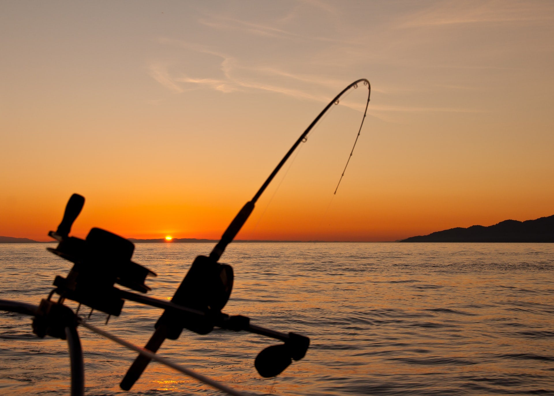 fishing rod mounted on a boat during sunset