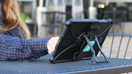 Person using a tablet with a stand